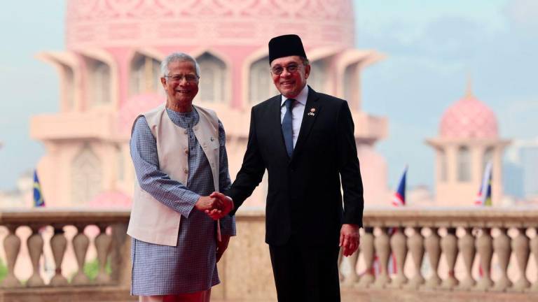 Perdana Menteri Datuk Seri Anwar Ibrahim (kanan) bersalaman dengan Ketua Penasihat Kerajaan Republik Rakyat Bangladesh Prof Dr Muhammad Yunus pada istiadat Sambutan Rasmi di Bangunan Perdana Putra di sini hari ini. - fotoBERNAMA