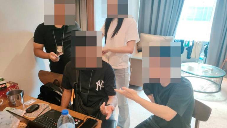 A Chinese national being questioned by enforcement officers during the raid on Oct 9. – PIC COURTESY OF IMMIGRATION DEPARTMENT