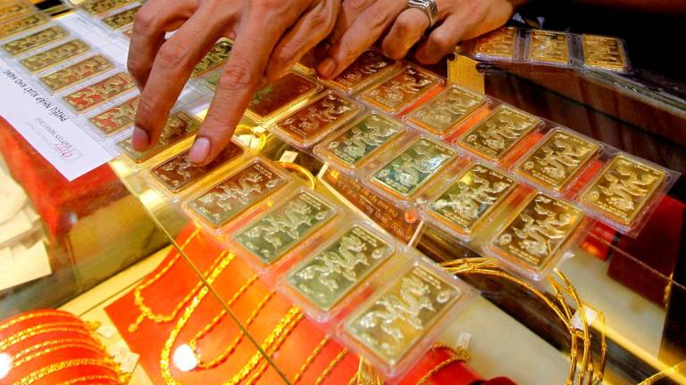 An employee counts some gold bars before he sells them to a customer at a gold shop in Hanoi August 23, 2011. REUTERSpix