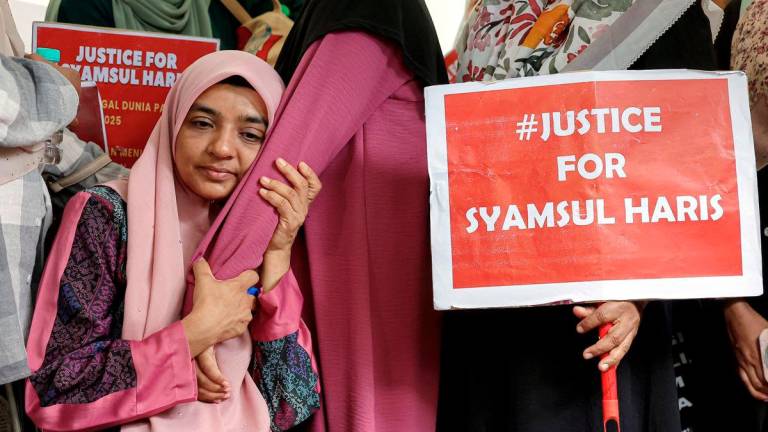 Ibu kepada pelatih Pasukan Latihan Pegawai Simpanan (Palapes) Universiti Teknologi Malaysia (UTM) Skudai, Syamsul Haris Shamsudin, Ummu Haiman Bee Daulatgun ditenangkan ahli keluarga dan sanak saudara semasa proses penggalian semula kubur anaknya di Tanah Perkuburan Islam Kampung Rinching Ulu. - BERNAMA