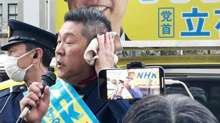 NHK Party chief Takashi Tachibana speaks after being attacked outside the Finance Ministry on Friday. Photos: AFP-JIJI via The Japan Times