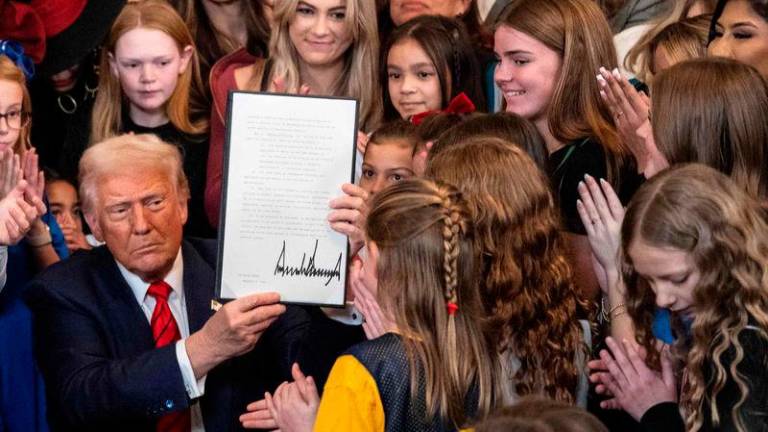 US President Donald Trump holds up the No Men in Women’s Sports Executive Order after signing it in the East Room of the White House - AFPpix