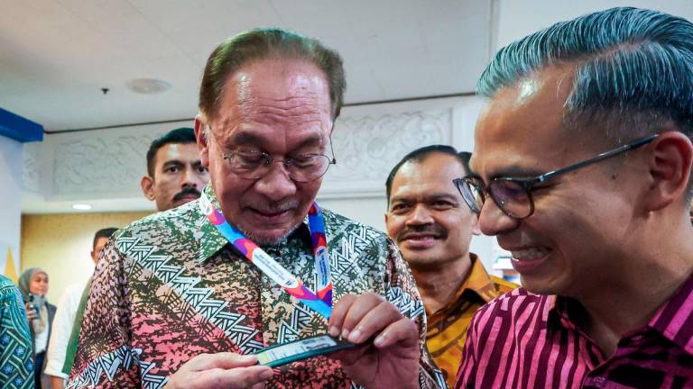 Perdana Menteri Datuk Seri Anwar Ibrahim melihat kad perakuan media pada Kemuncak Hari Wartawan Nasional 2025 di Dewan Merdeka Pusat Dagangan Dunia (WTC) hari ini. Turut sama Menteri Komunikasi Datuk Fahmi Fadzil. fotoBERNAMA