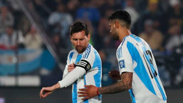 Argentina’s Lionel Messi receives the captains armband from Cristian Romero during the match REUTERS