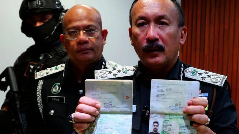 Ketua Pengarah Imigresen Datuk Ruslin Jusoh (kanan) menunjukkan salinan pasport ketika sidang media berhubung Operasi Sindiket Pemalsuan Dokumen Ofu Bhai di Bahagian Perisikan dan Operasi Khas Jabatan Imigresen Malaysia di Kompleks D, hari ini. - fotoBERNAMA