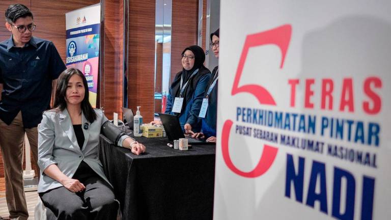 Timbalan Menteri Komunikasi Teo Nie Ching (tengah) melakukan pemeriksaan tekanan darah semasa melawat reruai pameran sempena perasmian Program Geran Digital PMKS MADANI (GDPM) Fest 2025 anjuran Suruhanjaya Komunikasi dan Multimedia (MCMC) hari ini-fotoBERNAMA
