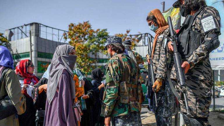 Taliban members stop women protesting for women’s rights in Kabul on October 21, 2021. Photo by AFP