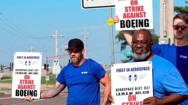 Workers hold signs during a walkout by members of the International Association of Machinists and Aerospace Workers (IAM) over contract negotiations, outside Boeing company's facility, in Berkeley, Missouri, U.S., August 4, 2025. - REUTERS