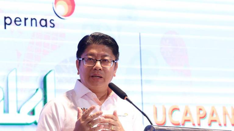 Menteri Pembangunan Usahawan Dan Koperasi Datuk Ewon Benedick menyampaikan sijil penyertaan kepada peserta program Halal Francise Conference di Meridien Hotel hari ini. - BERNAMA