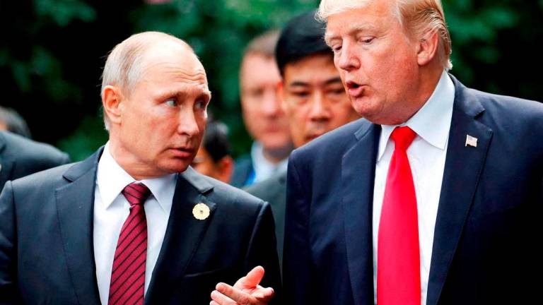 U.S. President Donald Trump and Russia’s President Vladimir Putin talk during the family photo session at the APEC Summit in Danang, Vietnam November 11, 2017 - REUTERSpix