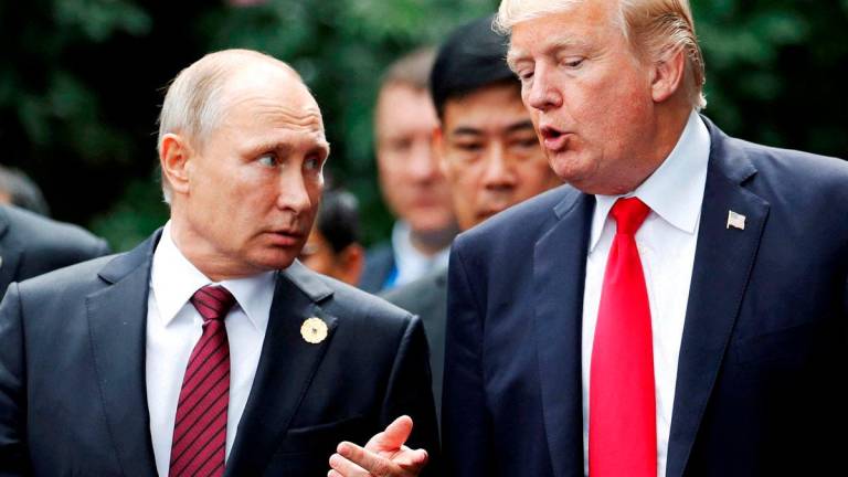 FILE PHOTO: U.S. President Donald Trump and Russia’s President Vladimir Putin talk during the family photo session at the APEC Summit in Danang, Vietnam November 11, 2017. REUTERS/Jorge Silva/File Photo