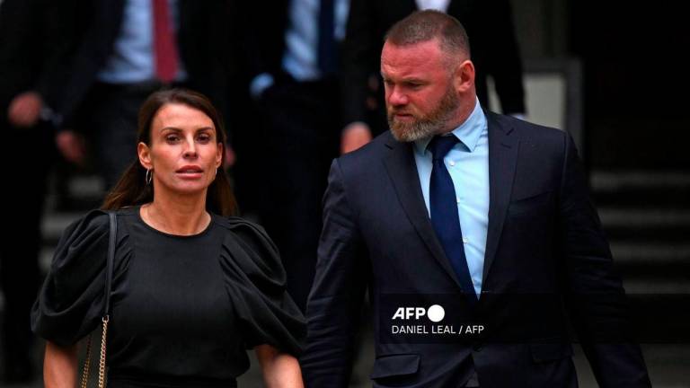 Coleen Rooney and her husband former England footballer Wayne Rooney, leave from the High Court in central London at the end of day three of the Wagatha Christie libel trial on May 12, 2022. - AFP