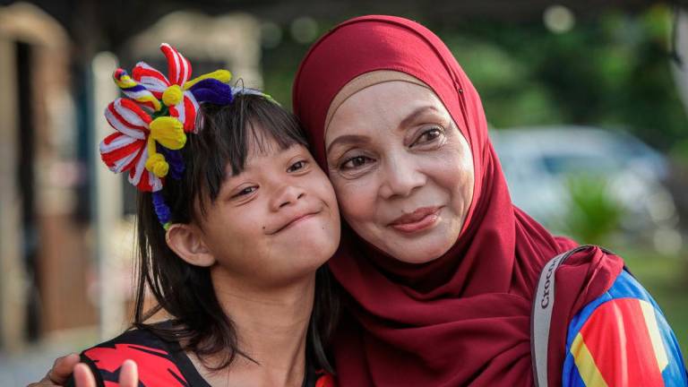 Rusliza Ahmad, 54, bersama anaknya Nur Hajar Alwi, 14, ketika ditemui pada Program Semarak Merdeka bersama Orang Kurang Upaya (OKU) Pertubuhan Pemulihan Dalam Komuniti (PDK) Jauhar Jannah sempena sambutan Hari Kebangsaan ke-68 di Sadiah Kafe, Wang Ulu di sini. - BERNAMA