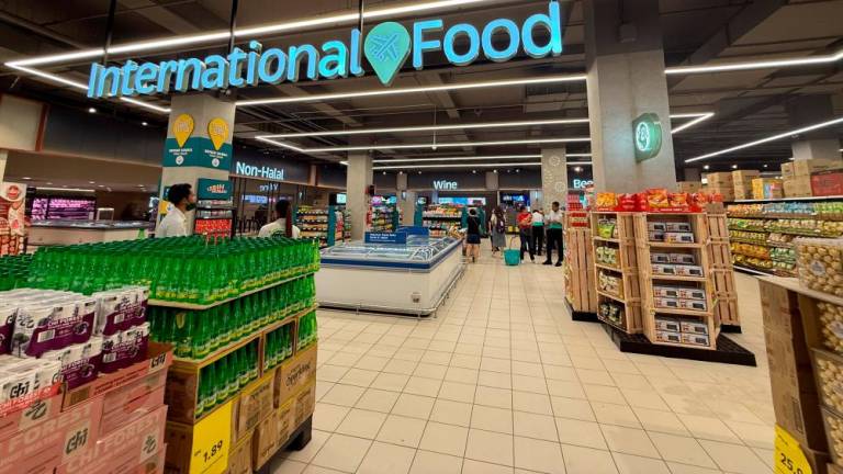 Customers shopping for groceries, sampling on food items at the redefined Lotus’s Paradigm that offers more than 14,000 products in store, with clear zoning and signages, and new offerings that cater to those who are also looking for premium selections.