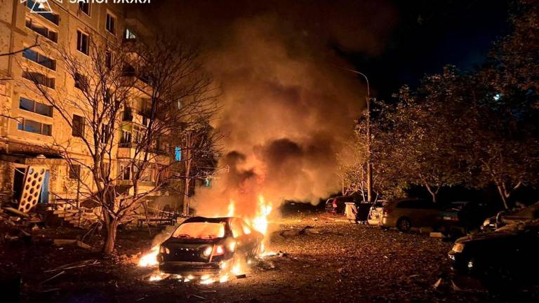 A car burns in front of an apartment building damaged during overnight Russian drone and air strikes, amid Russia’s attack on Ukraine, in Zaporizhzhia, Ukraine October 5, 2025. Press service of the State Emergency Service of Ukraine in Zaporizhzhia region/Handout via REUTERS