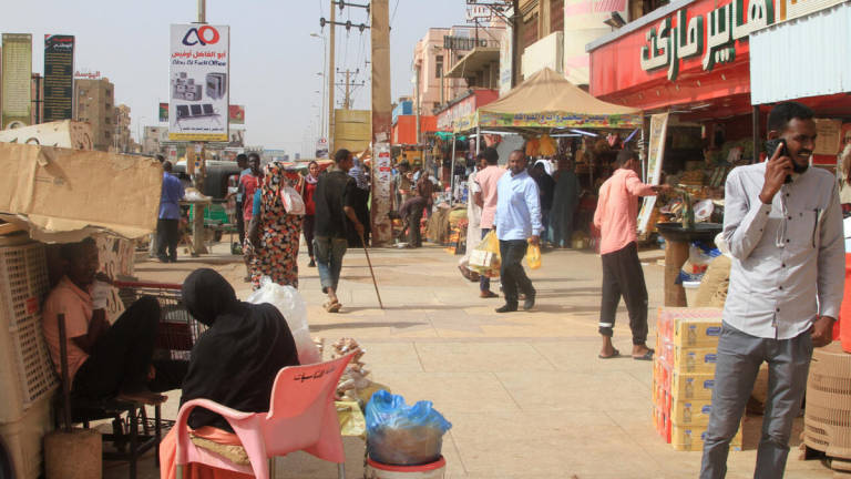 Sudanese walk past shops in Khartoum’s twin city Omdurman on July 29, 2025. - AFP