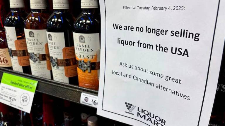 A sign notifying customers that a store will stop selling U.S. liquor from Tuesday, in response to U.S. President Donald Trump’s imposition of tariffs on Canada, is displayed on a shelf carrying U.S. alcohol in Winnipeg, Manitoba, Canada - REUTERSpix