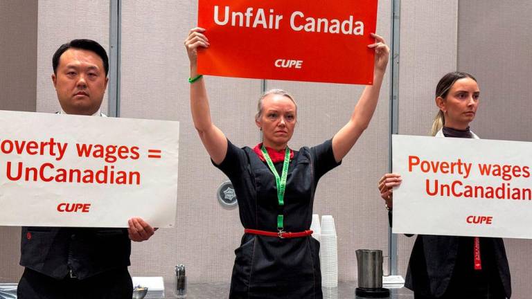 Union activists hold placards, as they interrupt a press conference by Air Canada executives, ahead of a potential strike by Air Canada flight attendants, at a hotel in Toronto, Ontario, Canada. Reuterspix