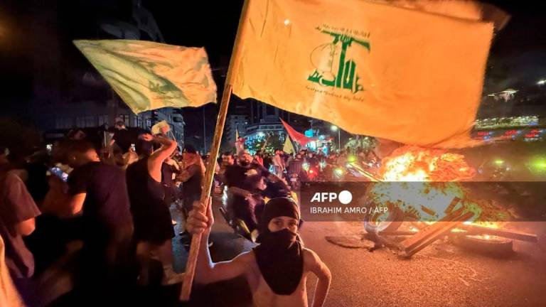 Supporters of Lebanon’s Hezbollah militant group block the streets with burning tires as they rally in cars and motorbikes to protest the government’s endorsement of a plan to disarm it, in Beirut’s southern suburbs early on August 8, 2025. - AFP