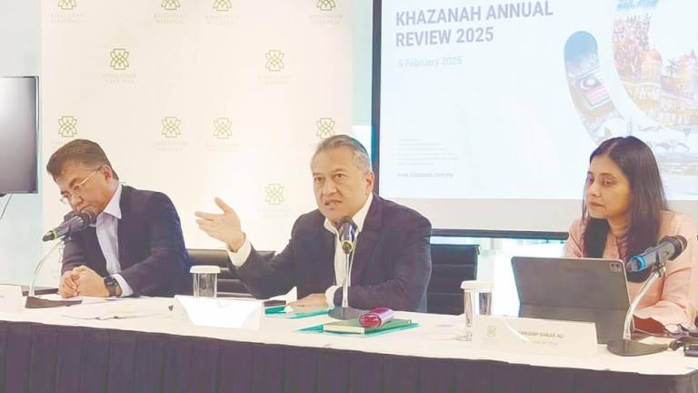 Amirul Feisal (centre) speaking at Khazanah Nasional’s press conference. He is flanked by chief investment officer Datuk Hisham Hamdan (left) and chief financial officer Faridah Bakar Ali.