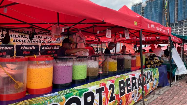 A vendor selling a colourful selection of drinks, perfect for breaking fast.