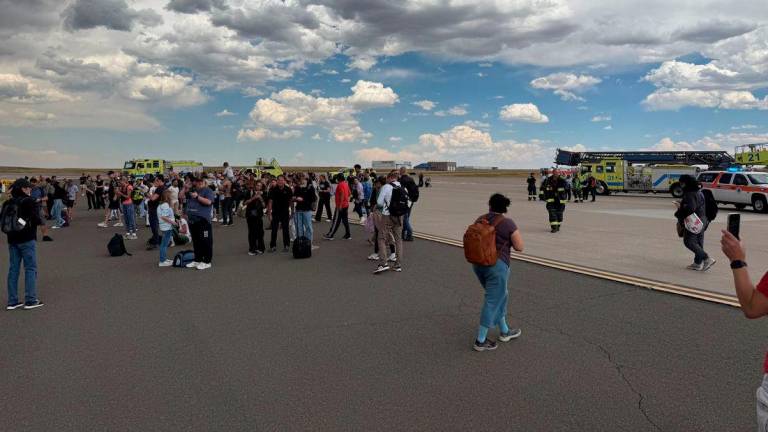 Passengers gather after evacuating an American Airlines plane that caught fire, at the Denver International Airport, Denver, Colorado, U.S. July 26, 2025, in this picture obtained from social media. @highlymigratoryfishing via Instagram/via REUTERS