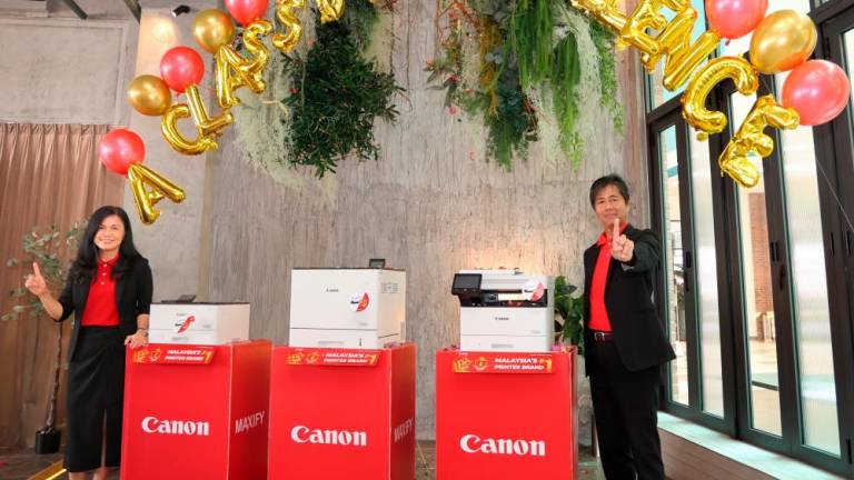 (From left) Lee and Yoshiie unveiling Canon’s next generation of laser printers. - PICS COURTESY OF CANON