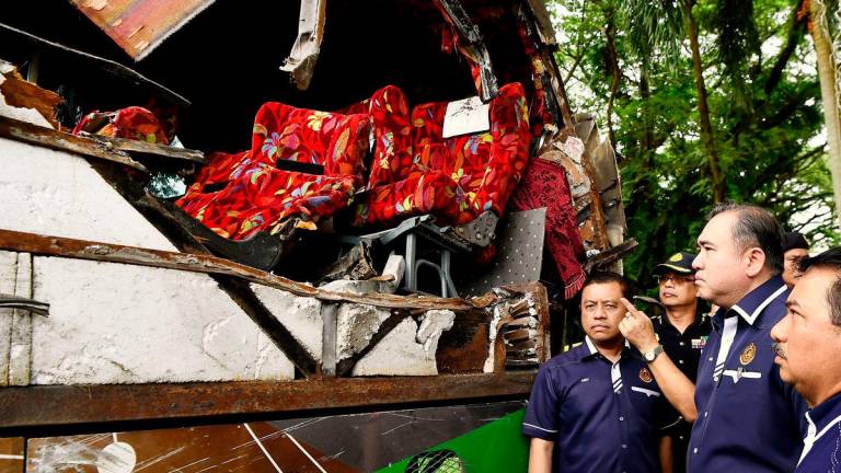 Menteri Pengangkutan Anthony Loke melihat keadaan bas yang terlibat dalam kemalangan membabitkan pelajar Universiti Pendidikan Sultan Idris (UPSI) di pekarangan Ibu Pejabat Polis Daerah (IPD) Gerik pada Jun 12. foto BERNAMA