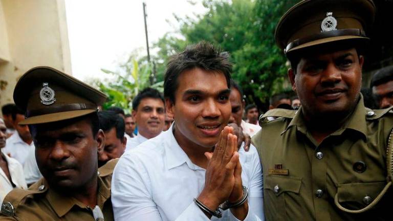 Namal Rajapaksa (C), son of former Sri Lanka’s President Mahinda Rajapaksa, leaves with prison officers at the court after being arrested in Colombo, Sri Lanka July 11, 2016 - REUTERSpix