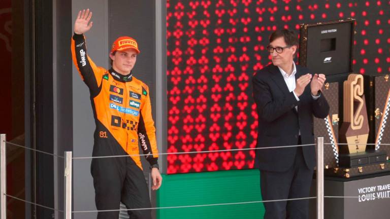 Catalan regional president Salvador Illa (R) looks at McLaren’s Australian driver Oscar Piastri waving from the podium after winning the Formula One Spanish Grand Prix at the Circuit de Catalunya in Montmelo, on the outskirts of Barcelona, on June 1, 2025. AFPpix