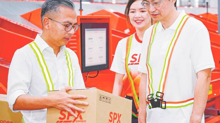 Fahmi (left) and Cheah (second, left) at the official opening of SPX Express’ Bukit Raja Selatan Sorting Centre today. – Bernamapic