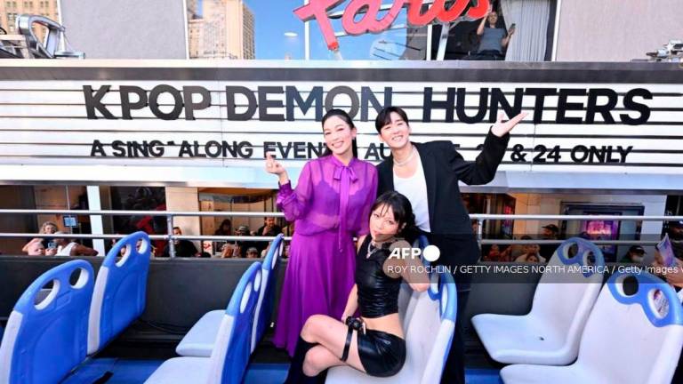 (L-R) Arden Cho, REI AMI and Kevin Woo hop on the KPop Demon Hunters-Sing Along Experience at Paris Theater on August 23, 2025 in New York City. - Getty Images via AFP