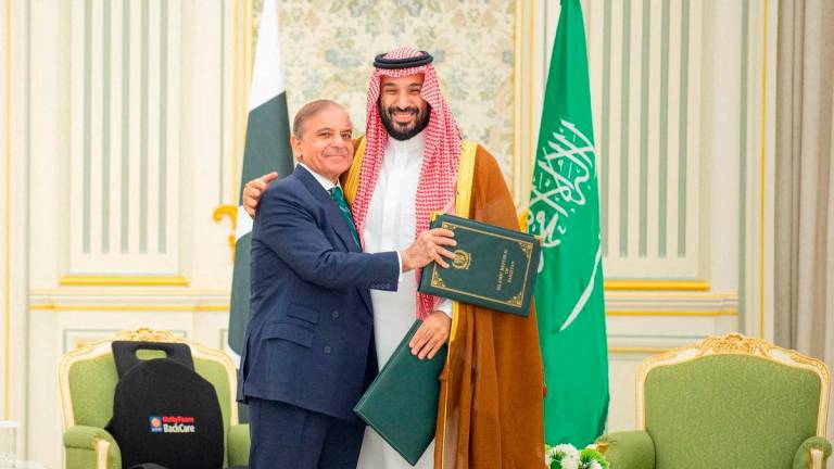 FILE PHOTO: Saudi Crown Prince Mohammed bin Salman and Pakistan Prime Minister Shehbaz Sharif embrace each other on the day they sign a defence agreement, in Riyadh, Saudi Arabia, September 17, 2025. Saudi Press Agency/Handout via REUTERS