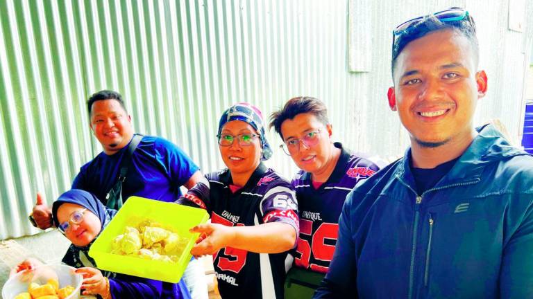 A group of Malaysian bikers enjoying durian in Thailand. – theSunpix