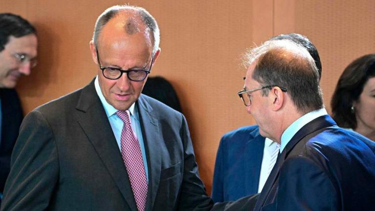 German Chancellor Friedrich Merz (L) talks with German Interior Minister Alexander Dobrindt before attending the weekly meeting of the German cabinet at the Chancellery in Berlin on July 2, 2025. (Photo by Tobias SCHWARZ / AFP)