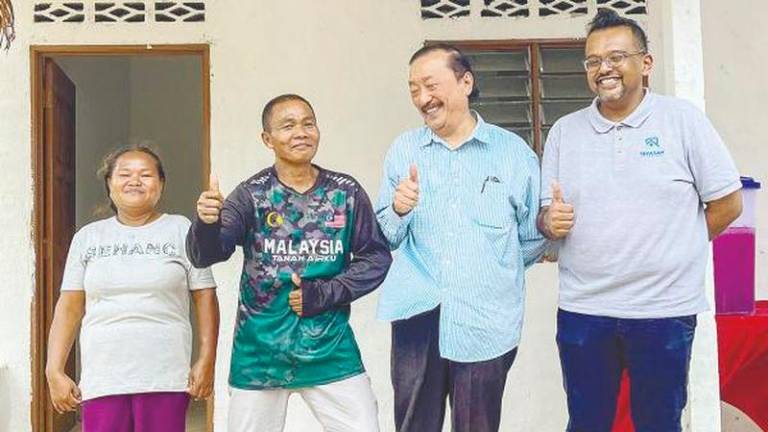 Tan, accompanied by Nambee Ashvin, with Chaman (second from left) and his wife Hawa after the handover of the home at Kampung Inoi Muadzam Shah in Pahang – Amirul Syafiq/theSun