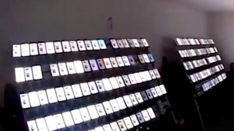 A passer-by noticed Ma managing hundreds of mobile phones arranged on shelves and suspected it was a scam operation, prompting them to alert the police. Photo: South China Morning Post via Weibo