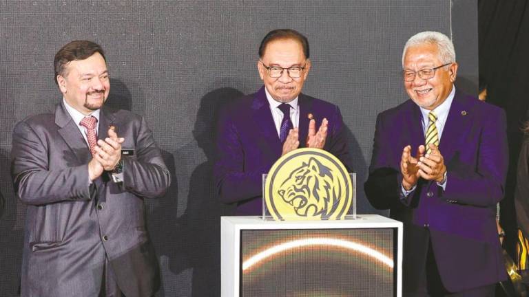 Anwar (centre), Finance Minister II Datuk Seri Amir Hamzah Azizan (left) and Maybank Group chairman Tan Sri Zamzamzairani Mohd Isa at the launch of myimpact SME Hub. – BERNAMAPIC