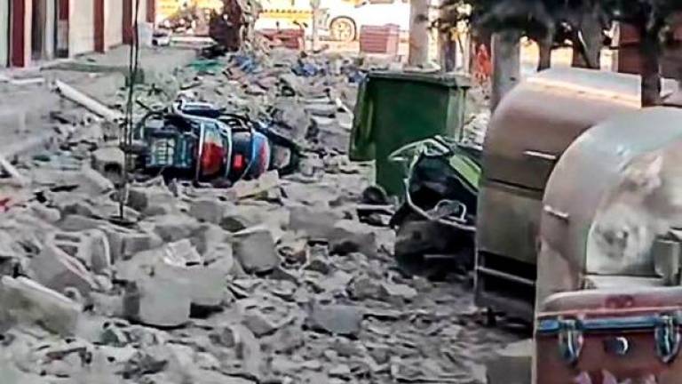 This frame grab from a user-generated content (UGC) video of a Douyin user on January 7, 2025 shows a fallen motorcycle amid debris on a road in Lhatse County in Shigatse city in China's Tibet after an earthquake struck the area. - AFPPIX