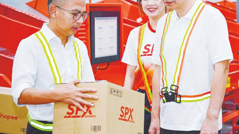 Fahmi (left) and Cheah (second, left) at the official opening of SPX Express’ Bukit Raja Selatan Sorting Centre today. – Bernamapic