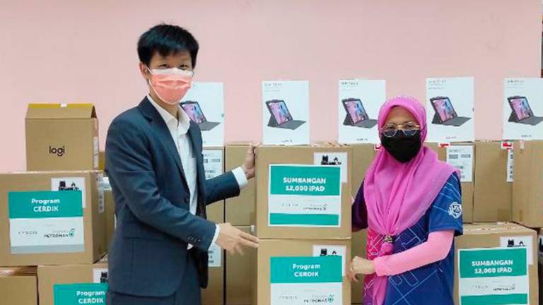 Saw Yu Shen, Yayasan PETRONAS’ Head of Operations (Education), handing over 353 devices on behalf of Yayasan PETRONAS to Siti Nurmala Md Nawi, the computer technician for the Petaling Perdana District Education Office, at Pusat Kegiatan Guru Puchong, to be distributed to students in the district.