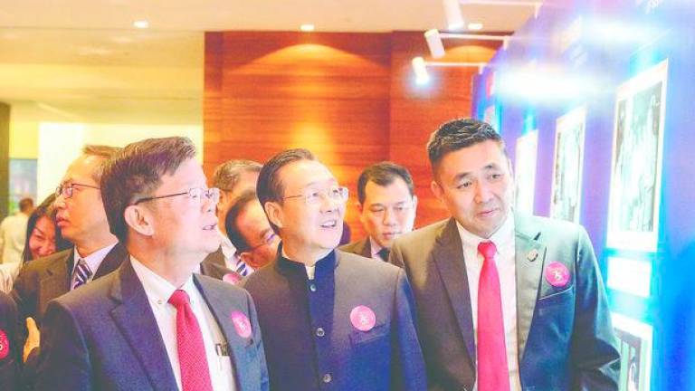 Chow (left) and Zhou (centre) viewing displays at an exhibition held during the event. – PIC COURTESY OF CHINA CONSULATE GENERAL