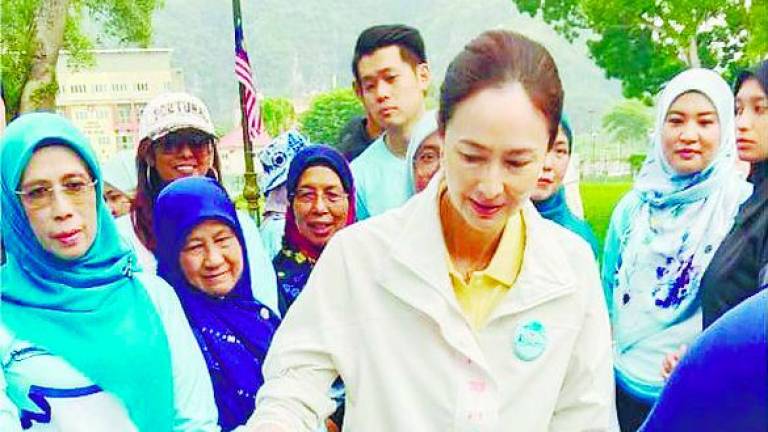Tuanku Zara watching a boy with disability display his skills.