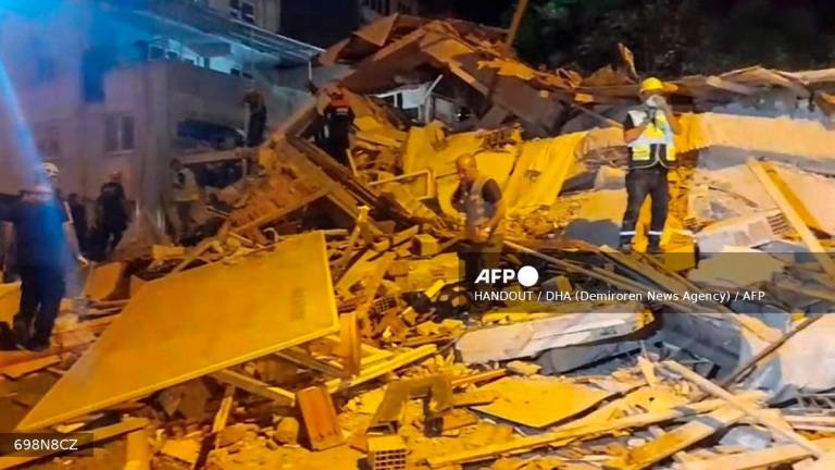 Rescue teams working in the rubble of a building in Balikesir province following a 6.1-magnitude quake that struck Sindirgi in western Turkey. (Photo by Handout / DHA (Demiroren News Agency) / AFP)