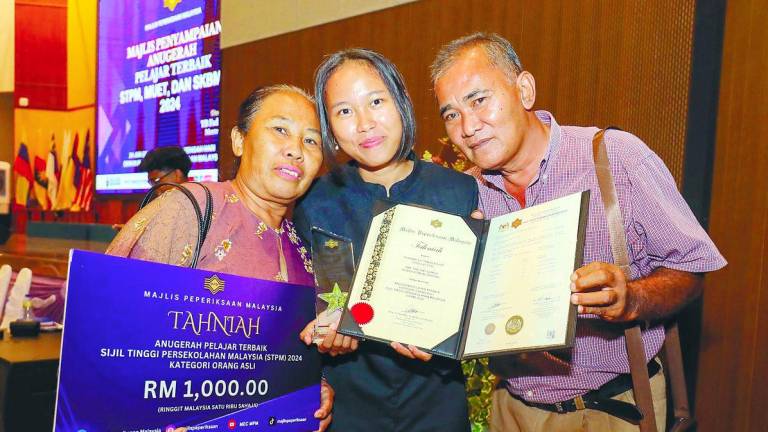 Roziana, the best student in the indigenous people category, with her parents during the awards ceremony for the best student in STPM, MUET and SKBMW 2024 at the Malaysia Examinations Council complex in Kuala Lumpur. – Adib Rahwi Yahya/theSun