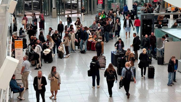 People line up at a service counter at the airport in Munich, after it was gradually resuming flights with delays expected through the day, hours after both runways were closed for the second time in less than 24 hours due to a drone sighting, in Munich, Germany, October 4, 2025. - REUTERSPIX