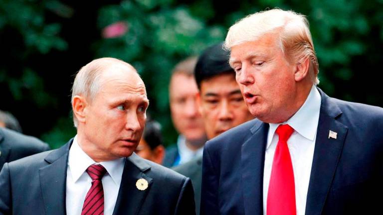U.S. President Donald Trump and Russia’s President Vladimir Putin talk during the family photo session at the APEC Summit in Danang, Vietnam November 11, 2017 - REUTERSpix