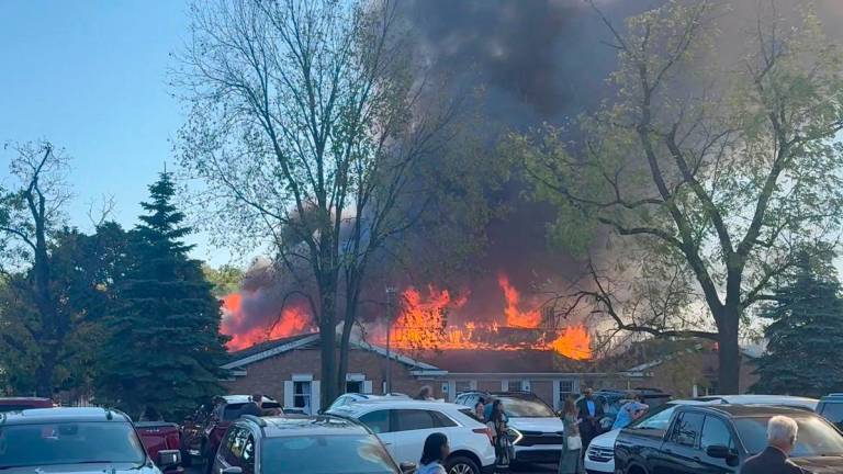 People gather at the site as smoke and fire rise, following an incident in which a man crashed his vehicle through the front doors of a Michigan church and opened fire with an assault rifle and set the church ablaze, in Grand Blanc, Michigan, U.S., September 28, 2025, in this screengrab obtained from social media video. Heem Vaniawala/via REUTERS