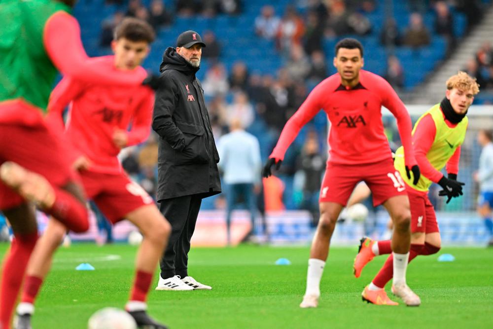 Jurgen Klopp (C) watches his players warm up ahead of the English FA Cup fourth round football match/AFPPIX