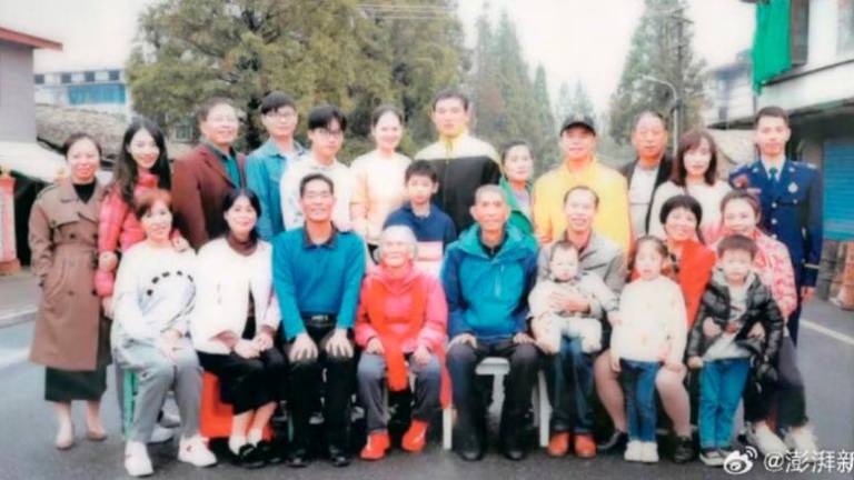 A group photo of those taken in by Tang Caiying, centre, shows the vast extent of her kindness. Photo: SCMP via Weibo